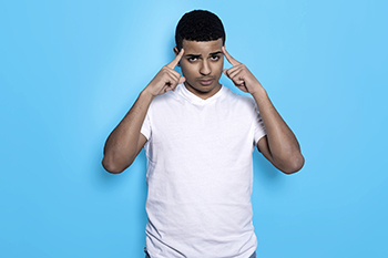 A boy pointing to his temples.